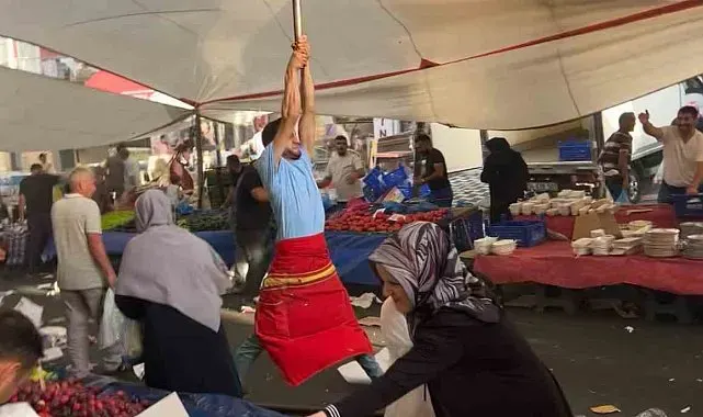 Kuvvetli rüzgarda pazarcı branda direğini bırakmadı, metrelerce havaya yükseldi