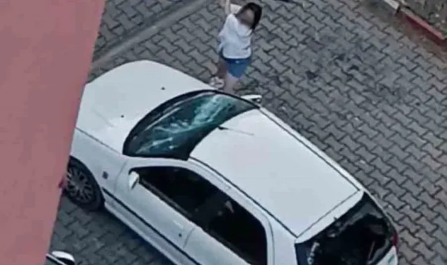 Park halindeki otomobilin camlarını kıran kadın kamerada