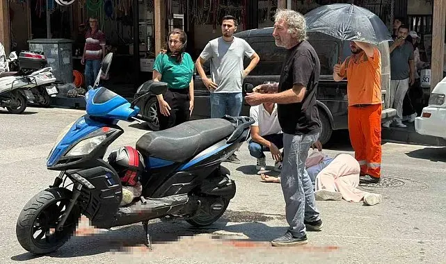 Kazada yaralanan genç kadına esnaftan şemsiyeli destek